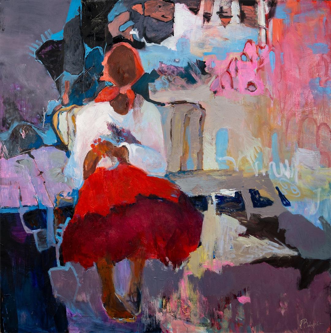 A person in a red skirt and white shirt sits looking down at something in their hands.